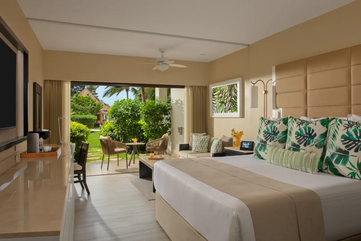 Junior Suite Garden View interior with king bed and garden-facing balcony at Secrets Wild Orchid Montego Bay.