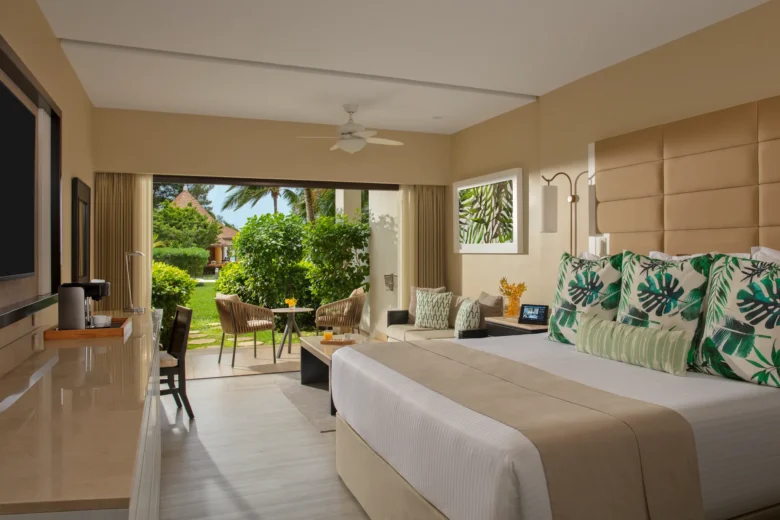 Junior Suite Garden View interior with king bed and garden-facing balcony at Secrets Wild Orchid Montego Bay.