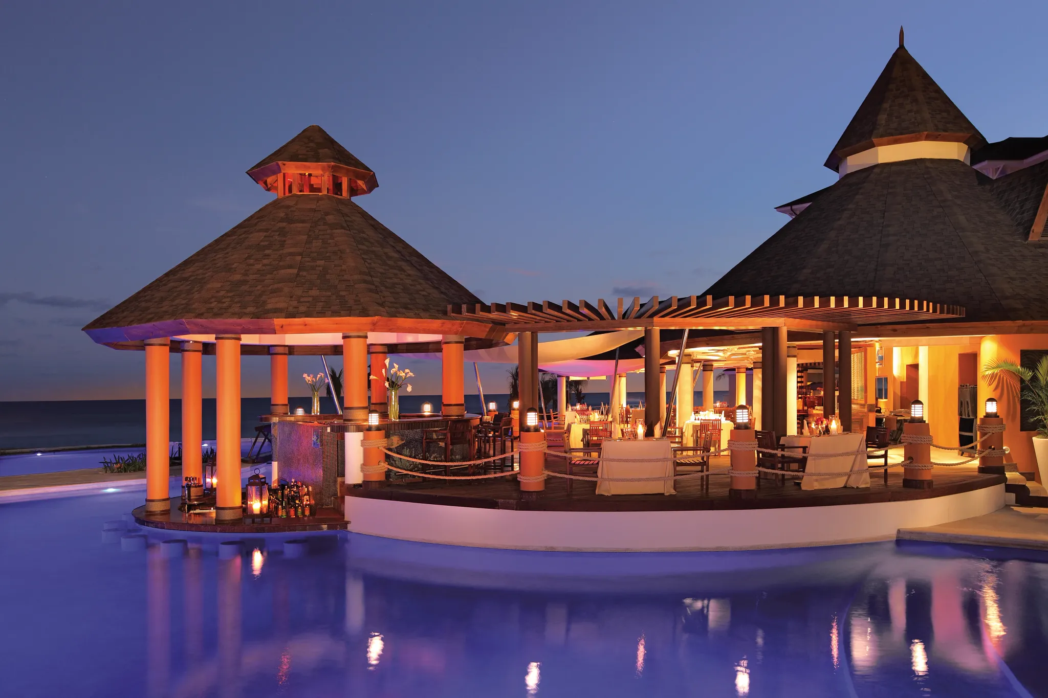 Oceana Seafood Restaurant at Secrets Wild Orchid Montego Bay featuring open-air oceanfront dining and elegant evening ambiance by the water.