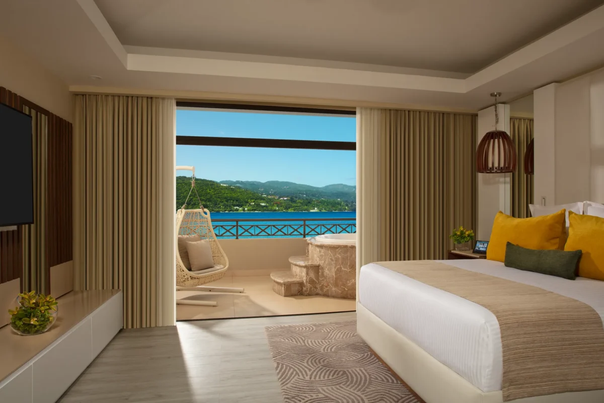 Preferred Club Presidential Suite king bedroom with oceanfront balcony access at Secrets Wild Orchid Montego Bay.