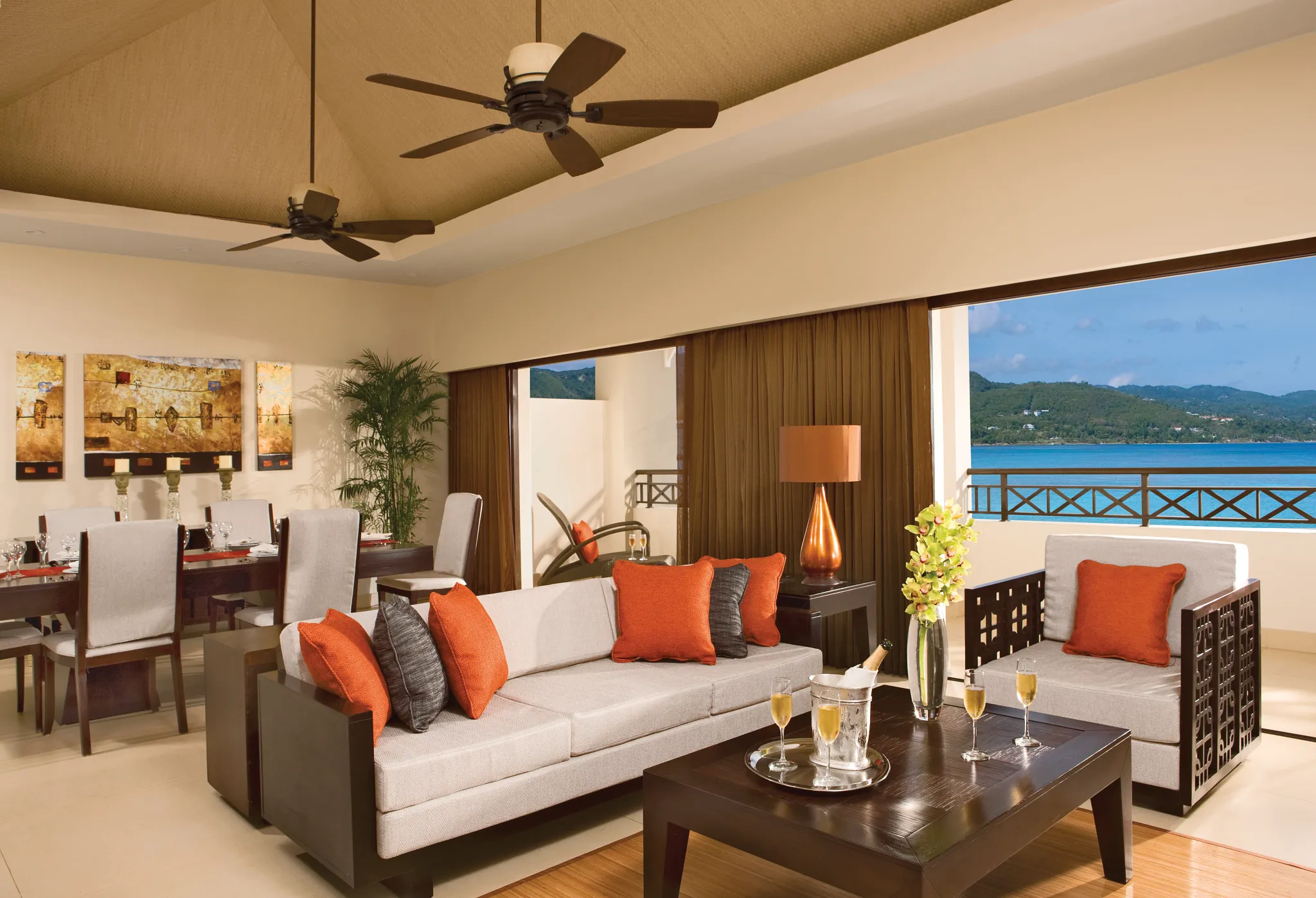 Preferred Club Presidential Suite living room with dining area and ocean views at Secrets Wild Orchid Montego Bay.