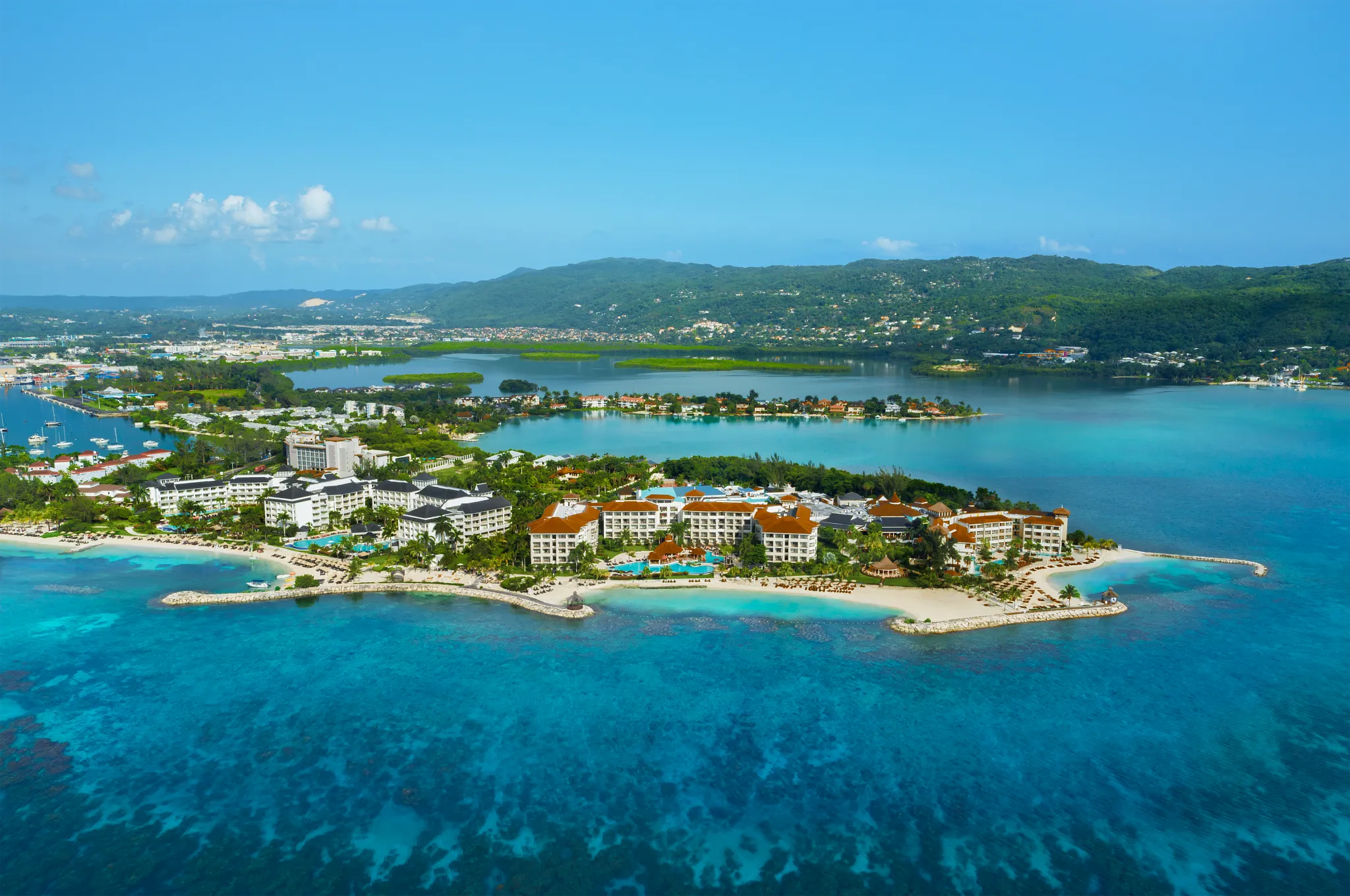 Aerial view of Secrets Wild Orchid Montego Bay on a private peninsula surrounded by turquoise Caribbean waters and white-sand beaches in Jamaica.