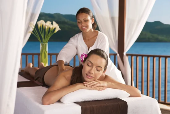 Woman receiving a relaxing beachfront massage overlooking the Caribbean Sea at Secrets Wild Orchid Montego Bay.