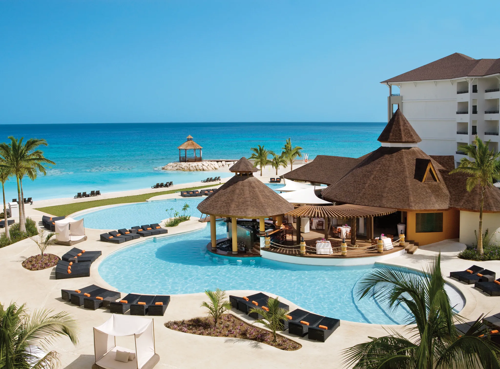 Oceanfront infinity-style pool with swim-up bar at Secrets Wild Orchid Montego Bay in Jamaica.