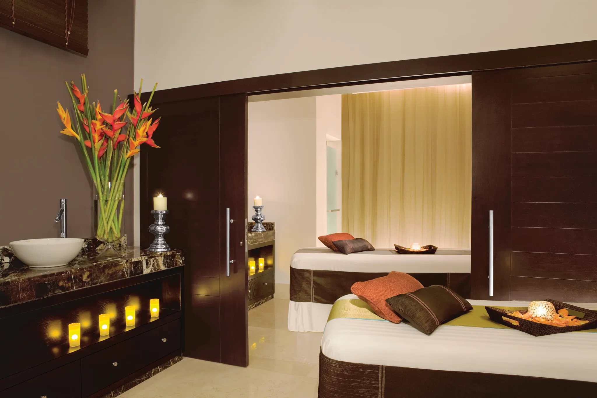 Luxury spa treatment room with massage tables and tropical decor at Secrets Wild Orchid Montego Bay in Jamaica.